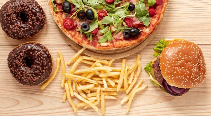 Fast food meal and junk food snacks comparison showing burgers, fries, pizza, chips, and sugary treats for understanding key differences in health impact.